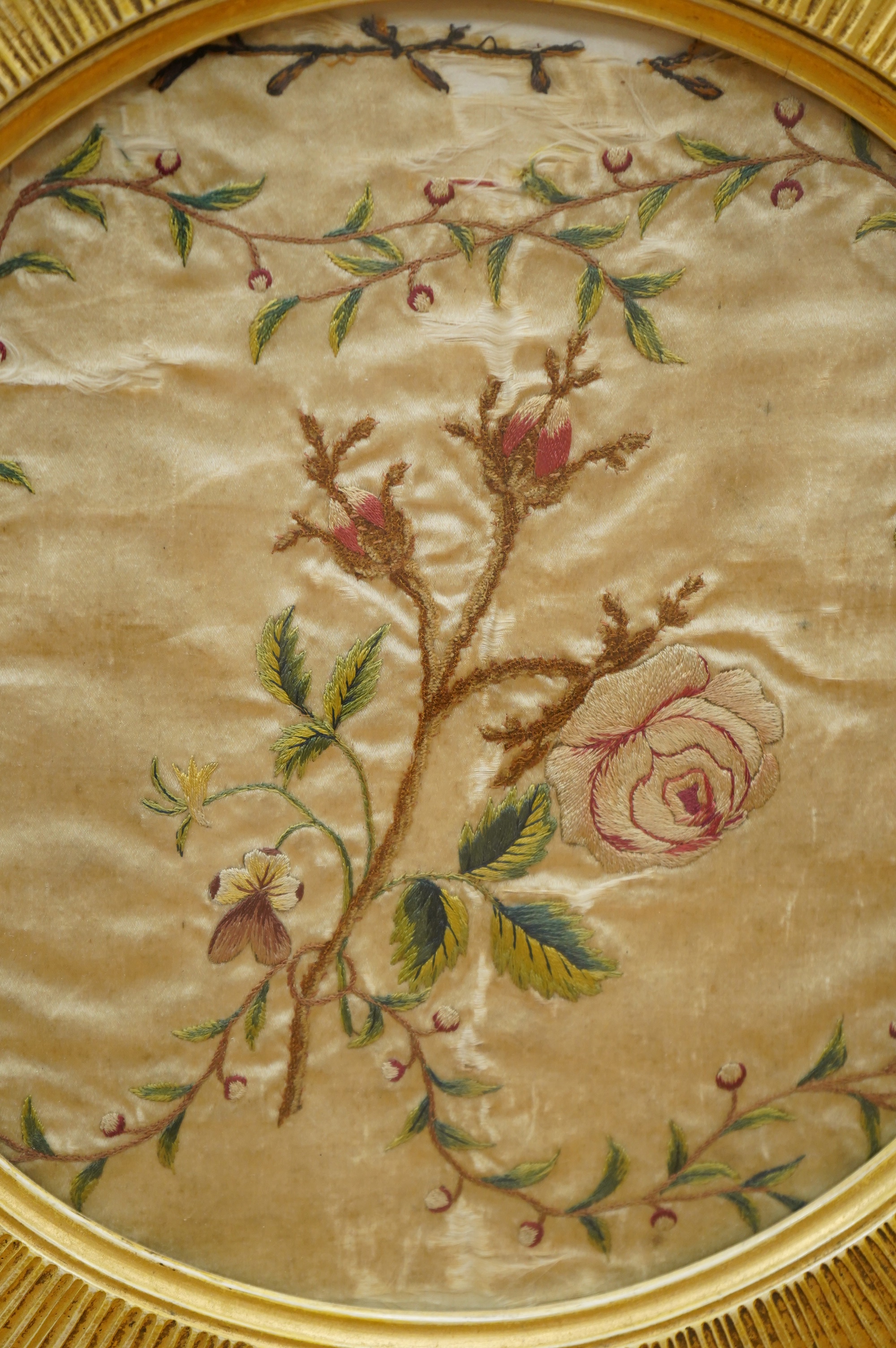 A late 18th century polychrome floral silk work embroidery of a cornucopia of flowers and a butterfly above, dated 1770, together with an early 19th century embroidery of a spray of roses surrounded by a floral border, w